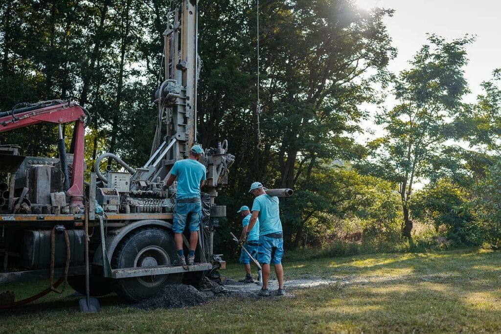 Borrigg och tekniker utför arbete vid tryckning av vattenbrunn